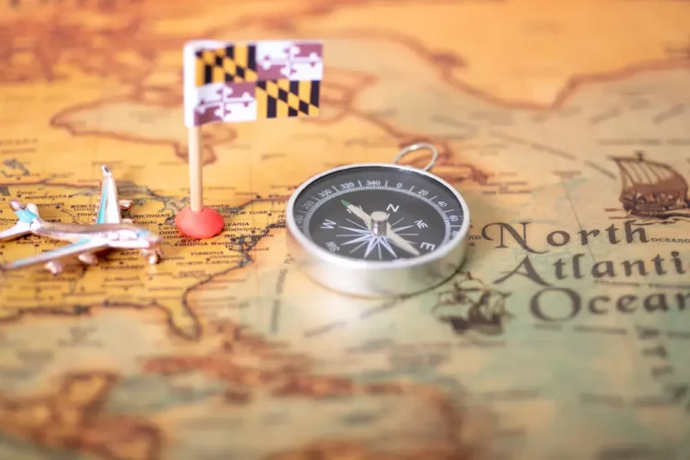 A vintage map with a Maryland flag, a silver compass, and a miniature airplane, symbolizing guidance and direction—just like the Best Family Law Office near me, helping families navigate legal matters with confidence.
