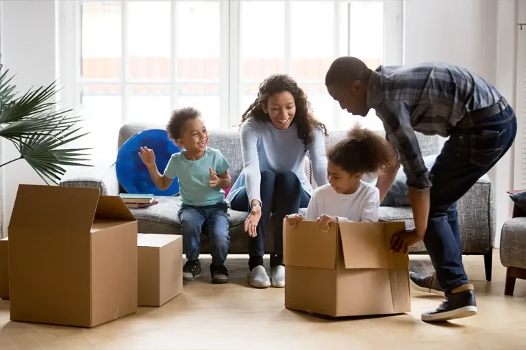 A joyful family unpacking moving boxes together, symbolizing the challenges and cooperation required for successful co-parenting while living under one roof during a divorce.